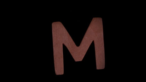 the letter m rising on black background