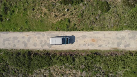 top down drone view following rental motorhome along small rocky road