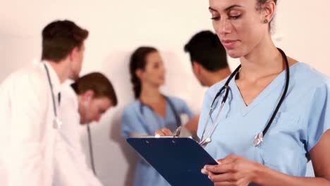 Portrait-of-a-nurse-writing-on-her-clipboard