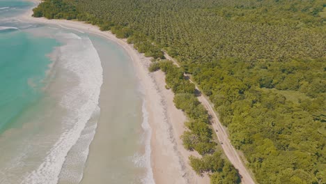 Blaue-Meereswellen-Berühren-Den-Strand-Im-Tropischen-Wald