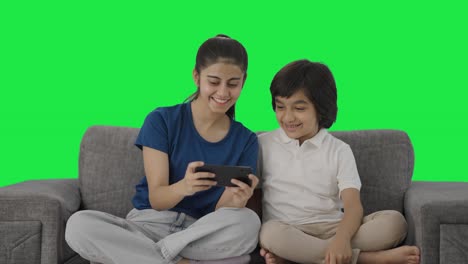 Happy-Indian-sibling-watching-video-on-mobile-phone-Green-screen