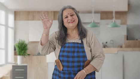 Happy-Indian-aged-housewife-saying-Hello-and-waving