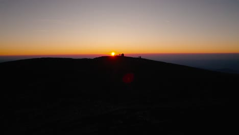 From-the-serene-embrace-of-dawn-to-the-mesmerizing-hues-of-sunset,-a-visual-journey-over-Austria's-majestic-peaks-and-valleys,-where-the-orange-light-transforms-the-scenery-into-a-surreal-dreamscape