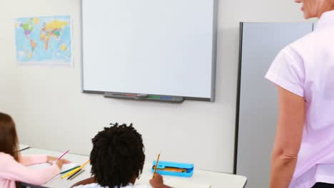 maestro ayudando a los niños con sus tareas en el aula