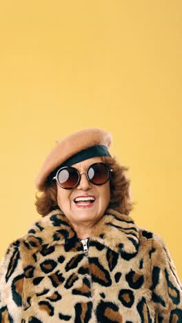 stylish elderly woman in leopard print coat and sunglasses