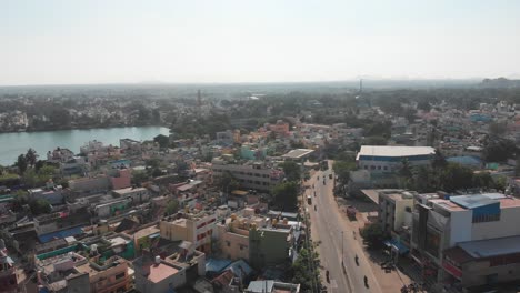vuelo aéreo a lo largo de la carretera principal en la ciudad de tiruvannamalai y estanque natural en el centro de la ciudad