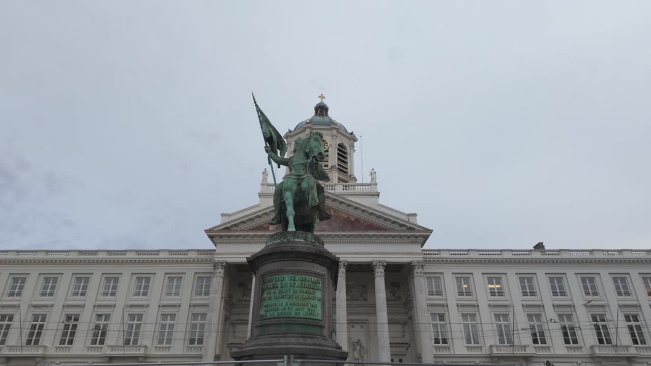 Equestrian statue of Godfrey of Bouillon with flag and shield, Place Royale and Church of Saint Jacques sur Coudenberg in Brussels, Belgium. Panning Shot