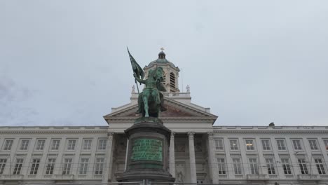 equestrian statue of godfrey of bouillon with flag and shield, place royale and church of saint jacques sur coudenberg in brussels, belgium. panning shot