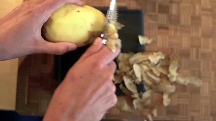 POV Shot of Female Hands Peeling a Potato