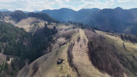 mountainous landscape with scattered cabins and lush greenery, seen from an aerial view