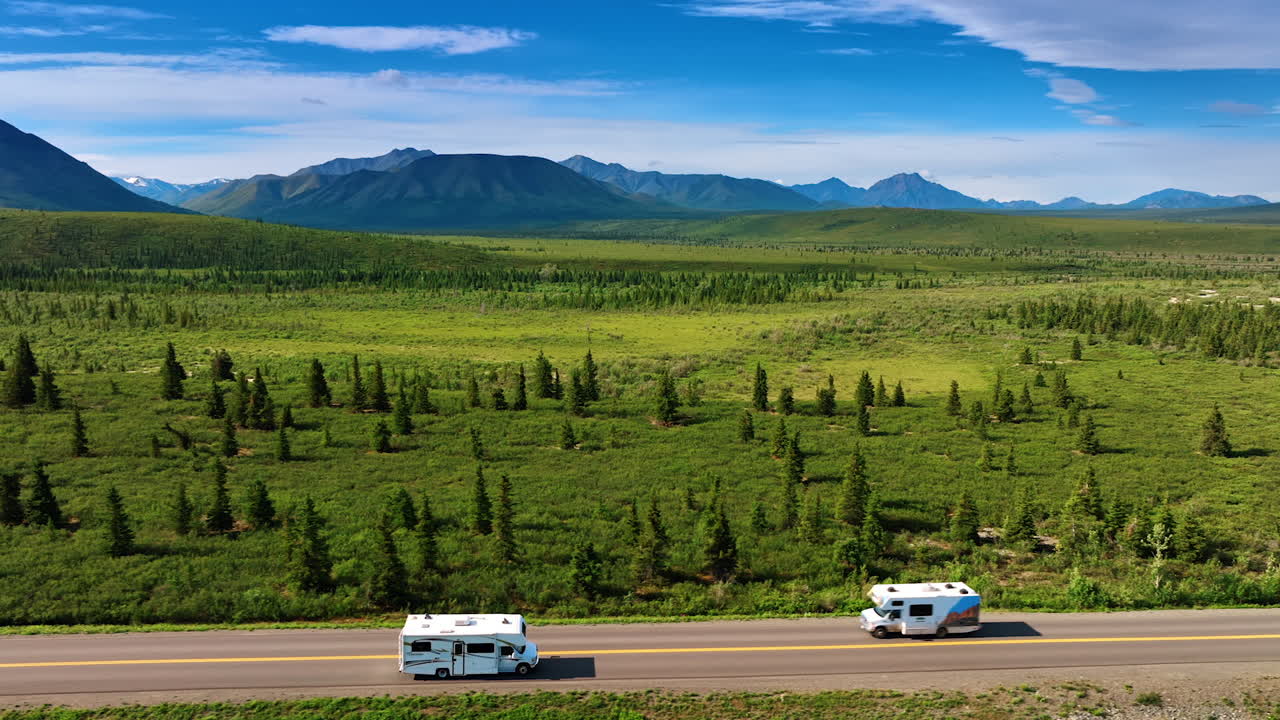Exploring Alaska wild roads. Enjoying a scenic drive in Alaska, with endless green fields and majestic mountains in the distance