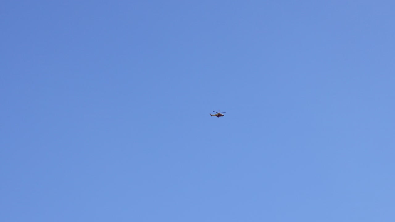 A helicopter flying in clear blue skies