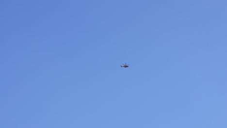 a helicopter flying in clear blue skies