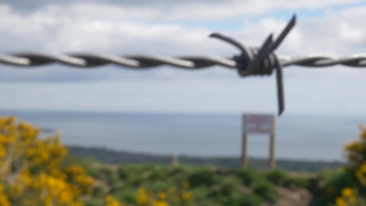 캐릭골로건 언덕에 무단침입 표지판이 없는 울타리에 사용되는 꼬인 와이어 코드의 매크로