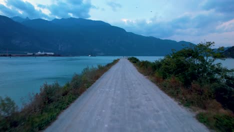 drone despega del puerto en el pintoresco paisaje canadiense que revela agua azul prístina y montañas