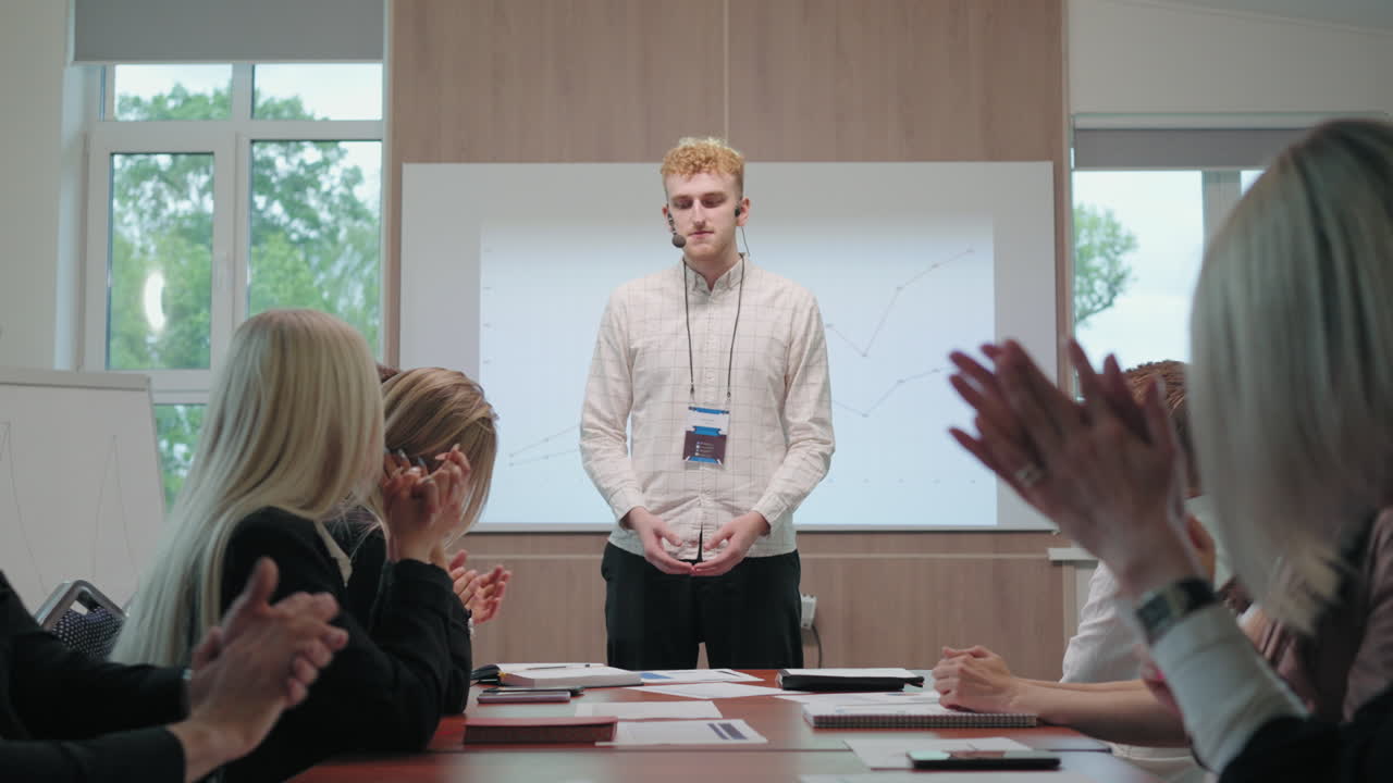 동료들은 회의실에서 비즈니스 회의에서 젊은 it 전문가를 박수를 치고 있습니다.