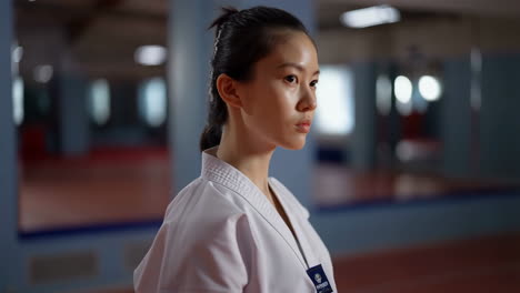 young woman in martial arts uniform in a dojo