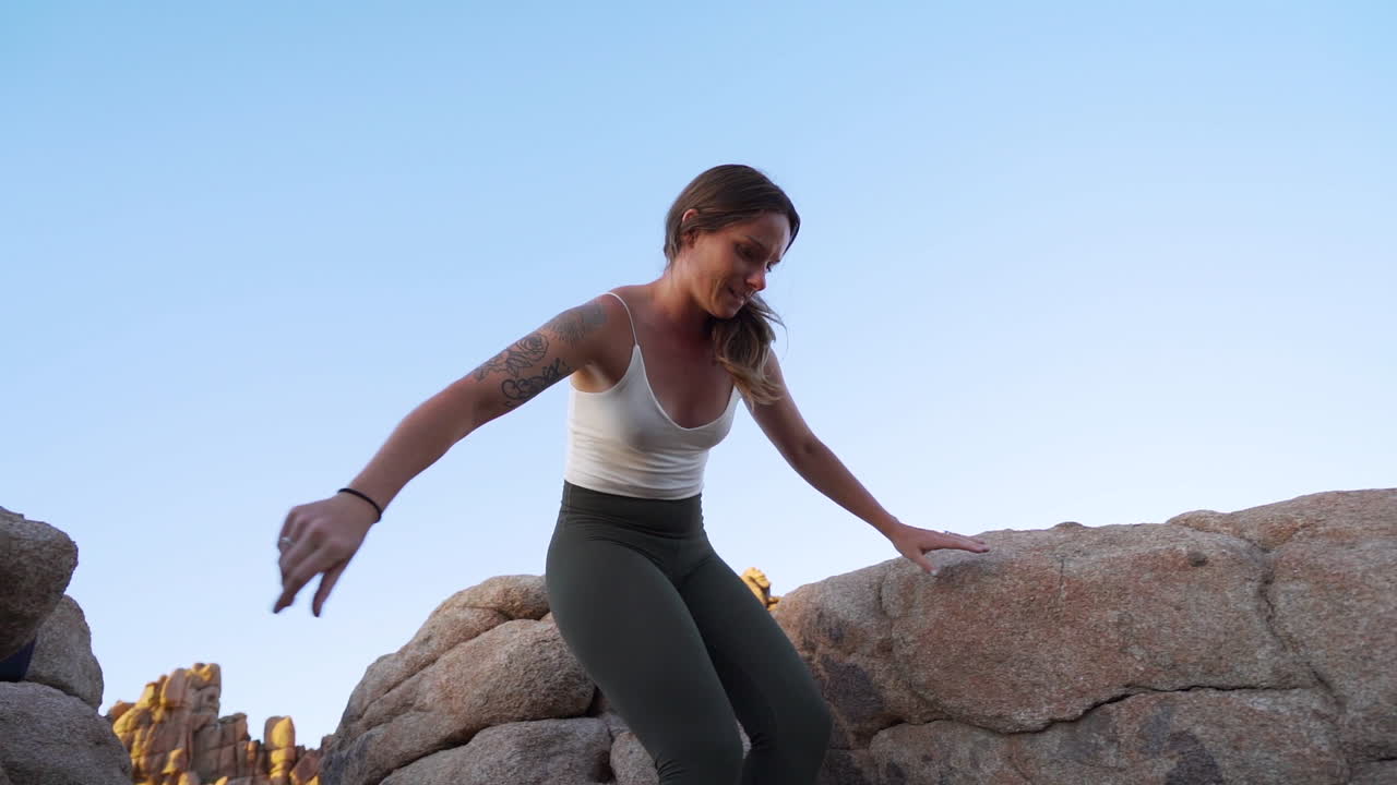 mujer atlética bajando rocas, caminando en el parque nacional
