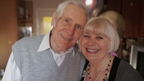 Portrait-of-a-happy-grandfather-and-grandmother-who-smiling-looks-at-camera