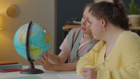 girl with down syndrome studying at home with teacher