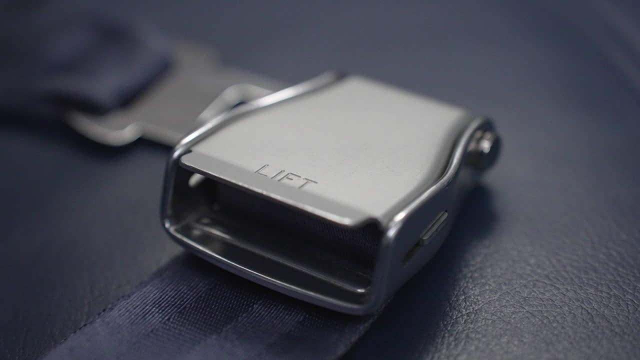 Airplane seat belt ready for a passenger on a commercial flight in case of an emergency - extreme close up