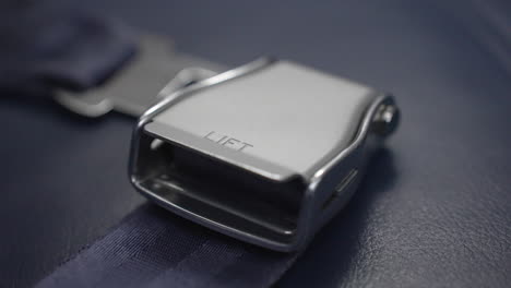 airplane seat belt ready for a passenger on a commercial flight in case of an emergency - extreme close up