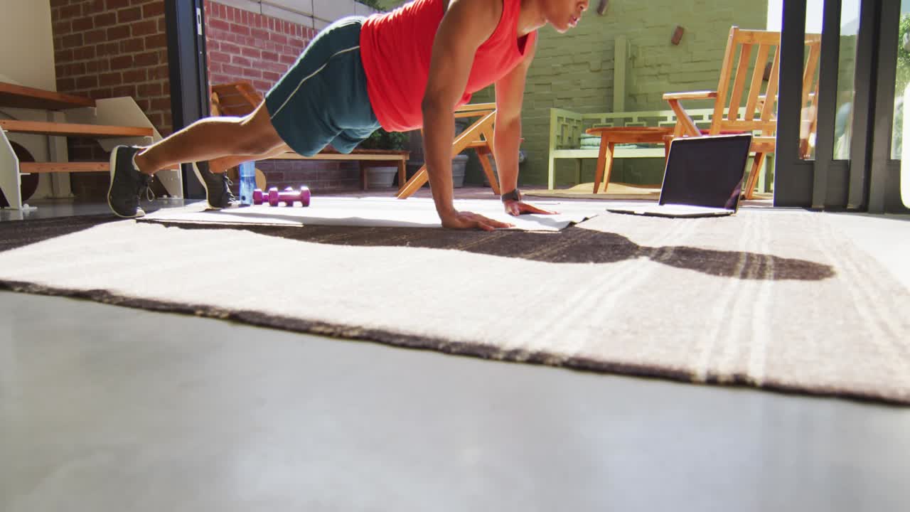 Man beginning plank and doing push-ups on rug, red HUD overlay tracking fitness progress over torso