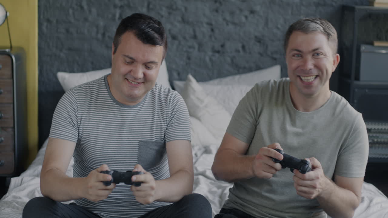 Two friends playing video games in a bedroom
