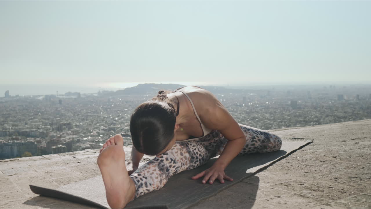 mujer haciendo yoga en el punto de vista de barcelona. entrenador de yoga estirando el cuerpo