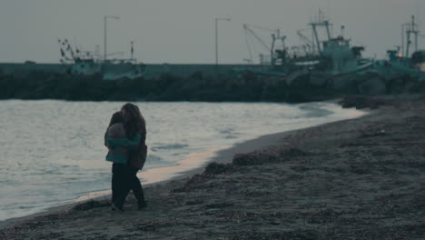 Mom-and-child-having-fun-on-the-beach-on-cold-day