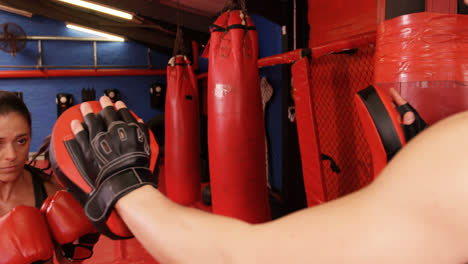 female boxer practicing with trainer