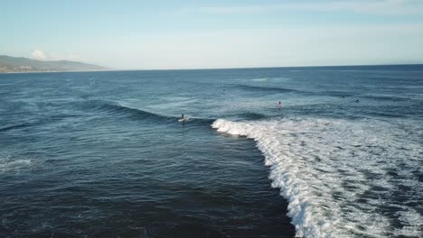 olas en la playa de malibu con surfistas