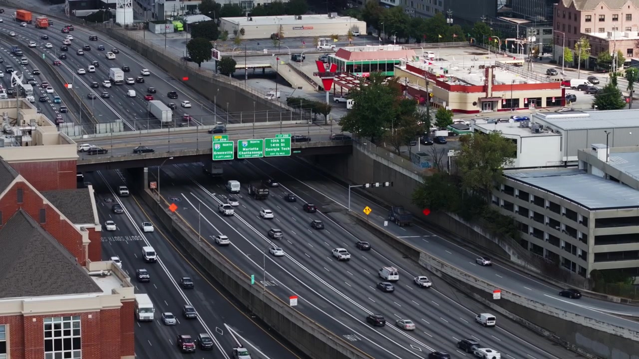 Lalu lintas di Downtown Connector dengan jembatan layang di Midtown Atlanta, AS. - Pengambilan gambar lebar.