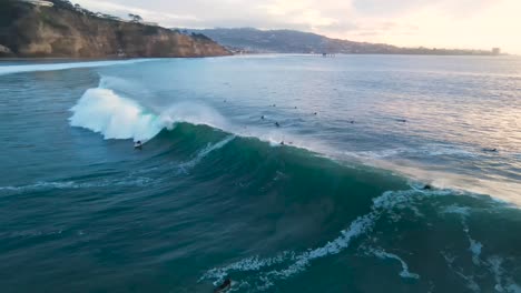 a surfer catches a wave at blacks beach