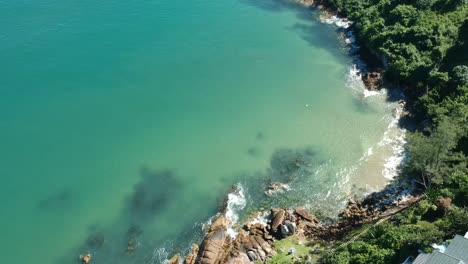 über-Einem-Strand-Mit-Klarem,-Blauem-Wasser-Schweben