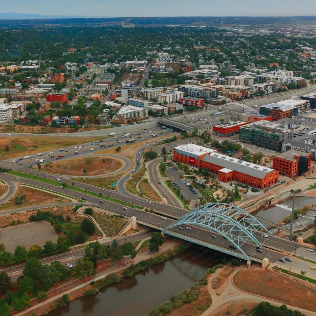 Roads, crossroads, bridges of beautiful Denver, Colorado, USA. South Platte River going parallel to busy highways. Green city panorama at backdrop