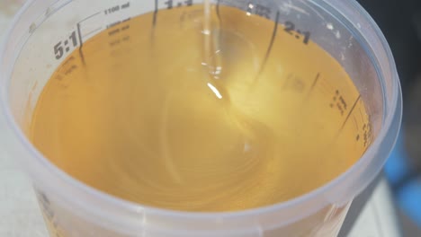stirring epoxy in container close up