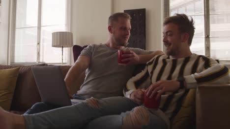 Caucasian-male-couple-in-social-distancing-in-their-sofa-at-home