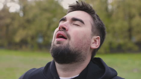 retrato de hombre respirando pesadamente en el parque por la mañana