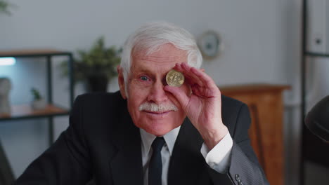 hombre de negocios anciano mostrando bitcoins dorados btc, minería de dinero, inversión, riqueza, ganancias, ingresos
