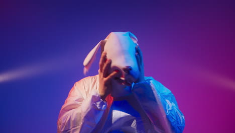 person wearing rabbit mask in neon light