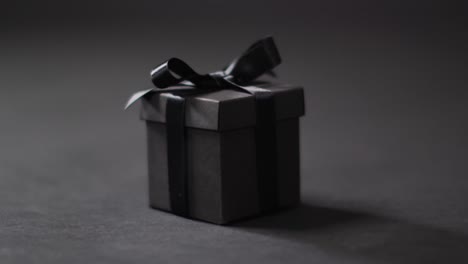 Schwarze-Geschenkbox-Mit-Schwarzem-Band-Auf-Dunkelgrauem-Hintergrund-Mit-Kopierraum