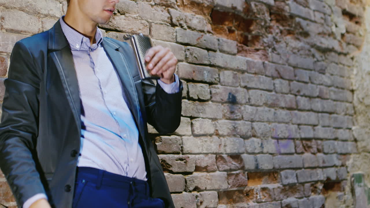 joven empresario frustrado bebiendo alcohol de matraces en una casa abandonada concepto depresión t