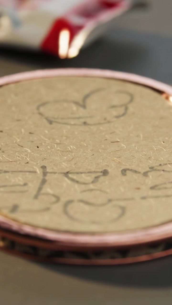 Vertical video: Panning cam showing fibrous craft top with pencil heart, pink rim, red tube on desk