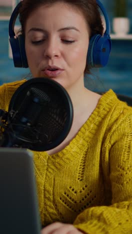 Vertical video: Vlogger looking at laptop while asking audience to subscribe on her channel