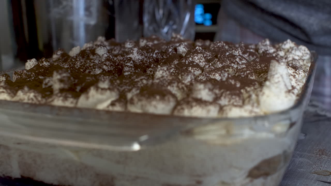 Cacao in polvere spolverato su dessert alla panna fresca su tavolo da cucina