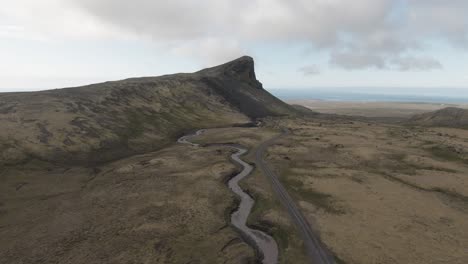 winding country river floating through mossy mountain side, lowering