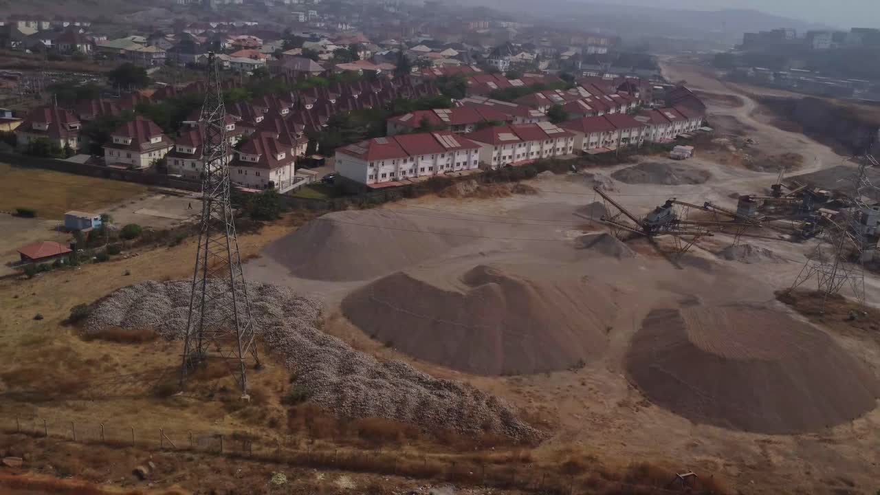 Ujęcie z góry z panoramowaniem od przemysłowego kamieniołomu w kierunku przedmieść w mieście Abudża, Nigeria.