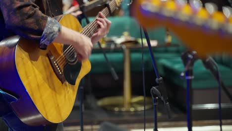 man playing the guitar with a band.