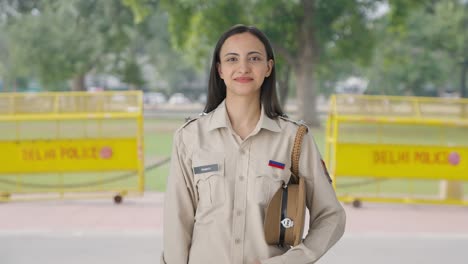 happy indian female police officer removing the cap